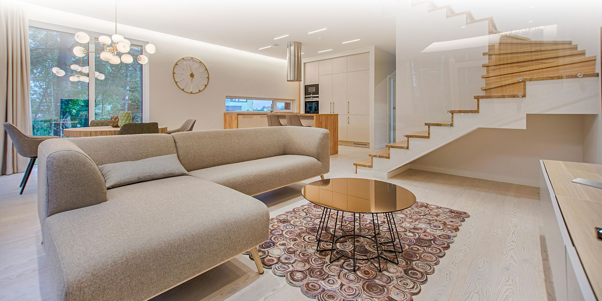 Imagem de uma sala ampla em cores claras, com janela ao fundo